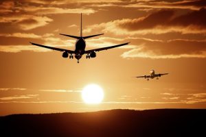 Commercial airliner flying against sunset